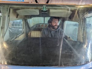 Uncle Alex in cockpit of plane at Cognitions in Beulah Michigan
