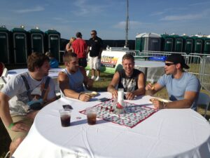 4 guys sitting at table with drinks.
