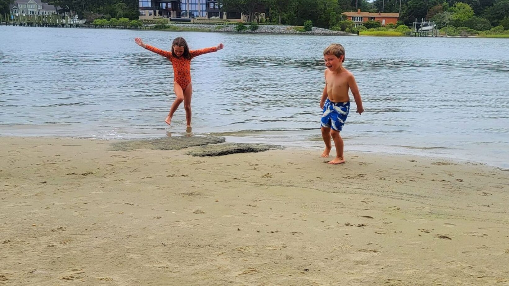 Anna and Brayden playing on the beach. Discover the best beaches in the Traverse City area! From family-friendly shores to quiet spots, enjoy Lake views, swimming, and more.